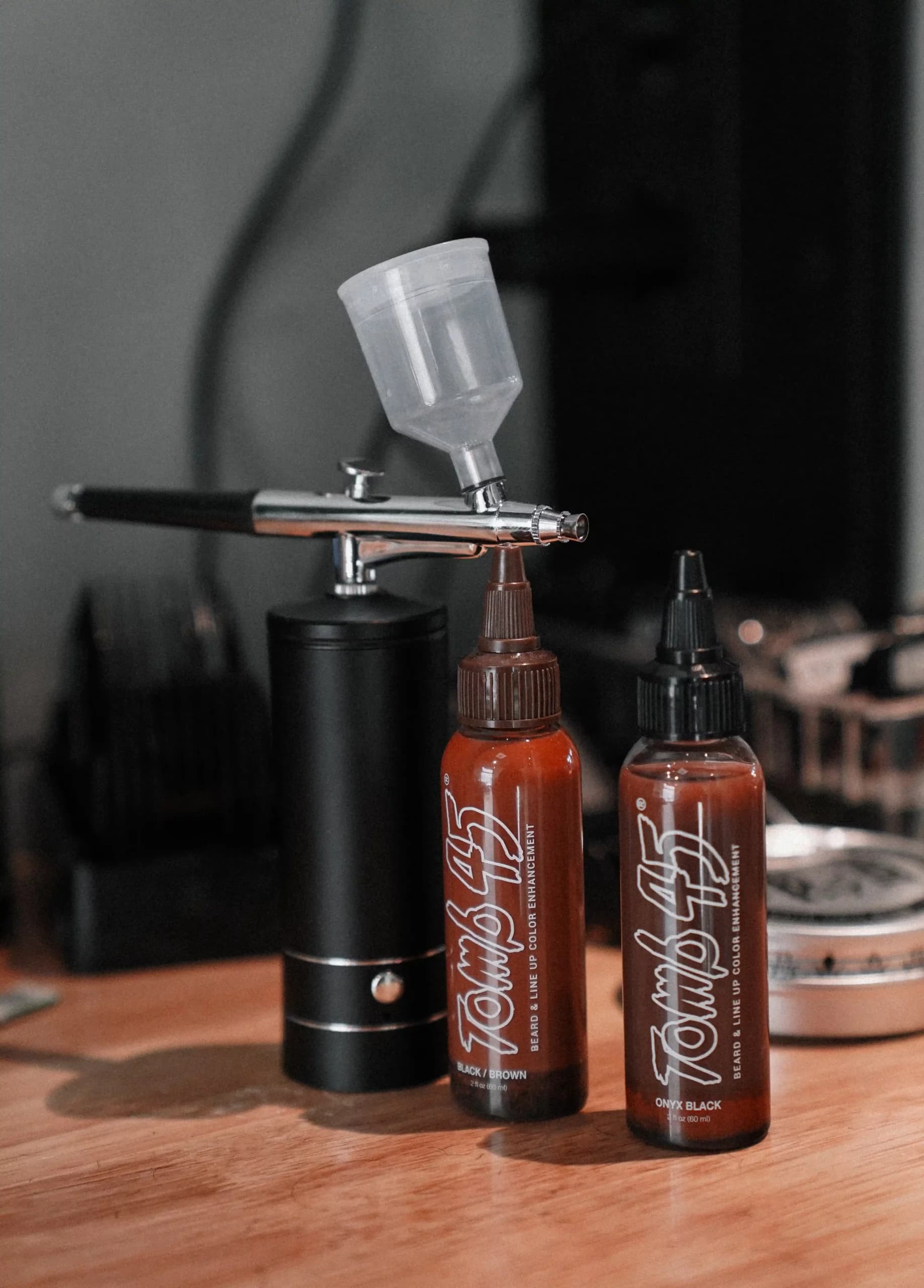 Airbrush gun and colour bottles on the worktop