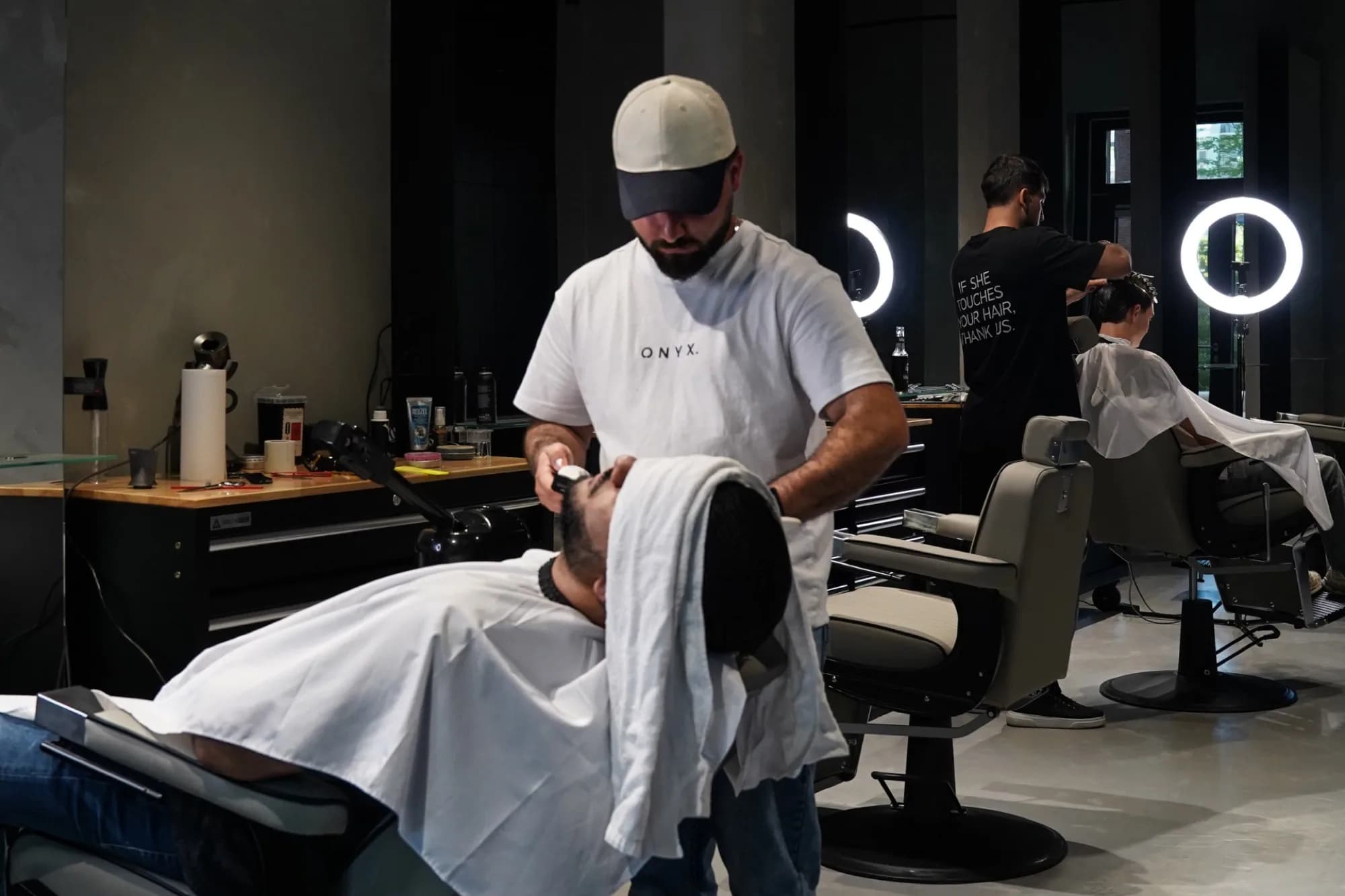 Barber bei ONYX Cuts in Wien beim Arbeiten am Stuhl