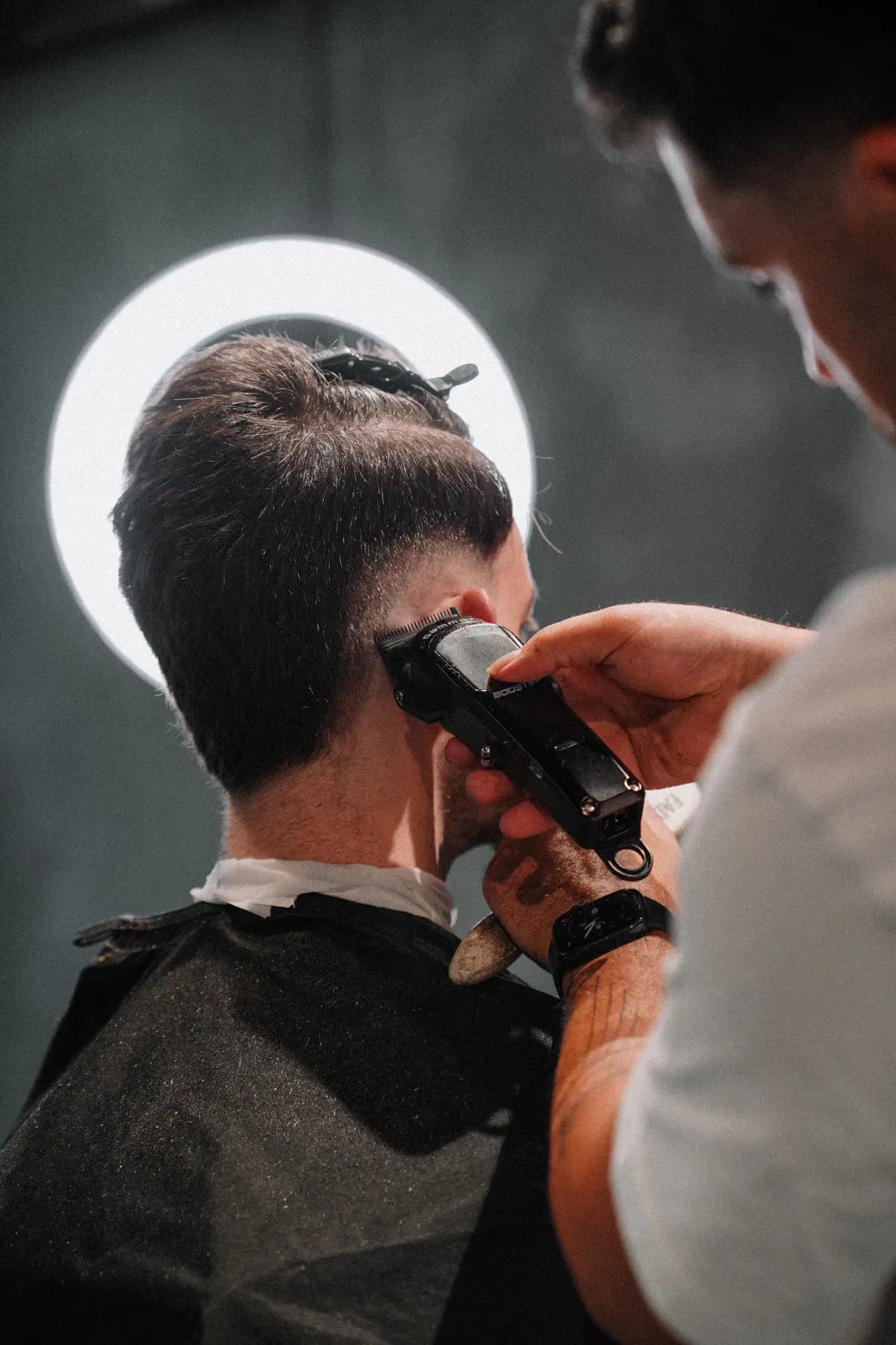 Barber setzt den Übergang im Nacken mit der Maschine, ONYX Cuts Wien